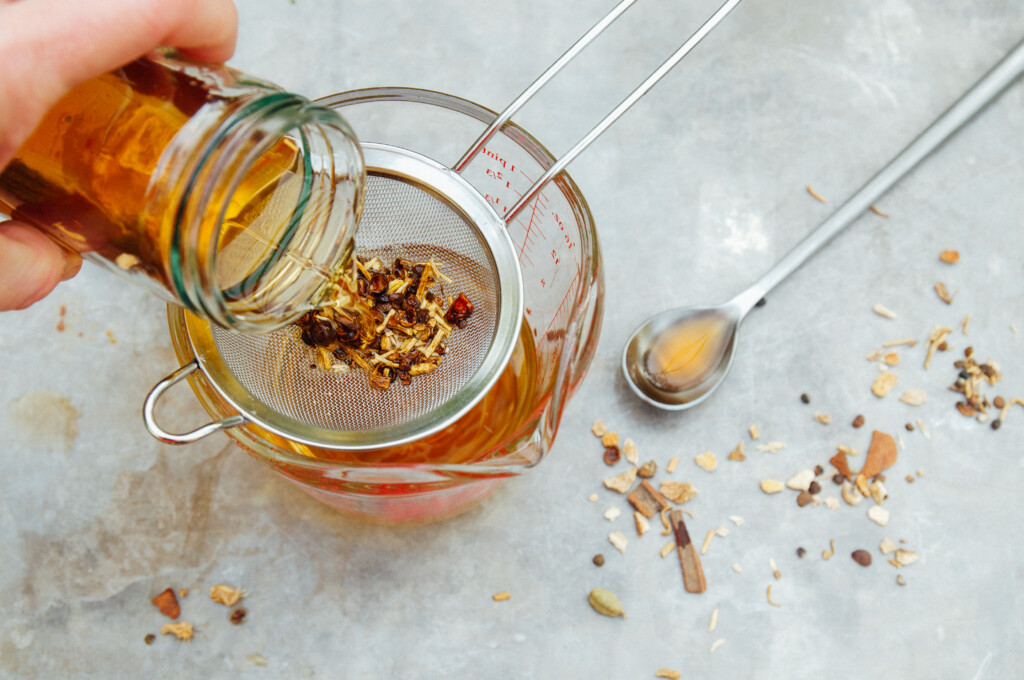 Making DIY bitters infusion with dried herbs, bark, and botanicals.